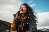 A Latina Mexican female backpacker sitting and gazing happily at the sky in Alaska laughing nature travel. 