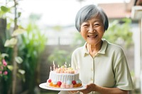 Elder Singaporean woman cake birthday dessert. AI generated Image by rawpixel.