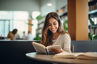 Latina student reading a book publication smiling library. AI generated Image by rawpixel.