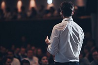 Man standing presenting project in conference hall audience adult shirt. AI generated Image by rawpixel.