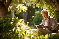 Elderly man enjoying a book in a serene garden setting surrounded by lush greenery reading publication relaxation. AI generated Image by rawpixel.