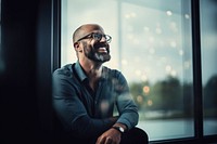 Man in glasses smiling laughing at a window sitting adult smile. AI generated Image by rawpixel.