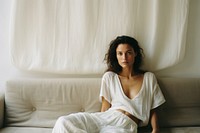 Woman on sofa behind a white curtain furniture portrait sitting. 