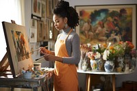 African American student wearing apron painting on a painting concentration entrepreneur paintbrush. AI generated Image by rawpixel.