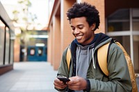 Smiling African student in backpack looking at cellphone on street architecture portability electronics. AI generated Image by rawpixel.