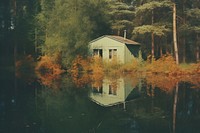 A littel house in woodland with lake architecture landscape building. AI generated Image by rawpixel.