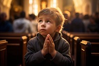 Young kid praying in church for God child adult spirituality. AI generated Image by rawpixel.