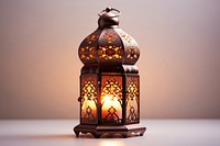 Ornamental Arabic lantern with burning candle glowing lamp illuminated decoration. AI generated Image by rawpixel.