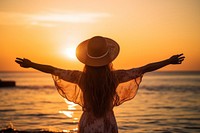 Happy woman weating a hat with arms up enjoy freedom at the beach at sunset outdoors nature adult. AI generated Image by rawpixel.