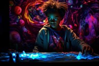 A little black boy painting neon color cute concentration illuminated. AI generated Image by rawpixel.