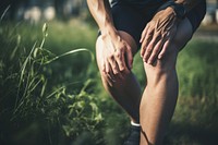 A man is holding his knee plant pain midsection. AI generated Image by rawpixel.
