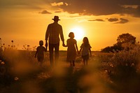 Silhouette of a family walking outdoors sunset. 