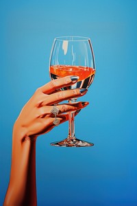 A hand holding a small Champagne champagne drink glass. 