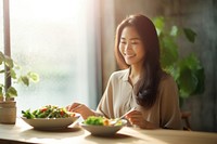 A beautiful asian girl eating salad food adult happy. AI generated Image by rawpixel.