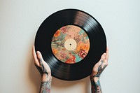 Tattoo hands holding vinyl record photography gramophone technology. AI generated Image by rawpixel.