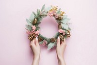 Hand holding pine wreath christmas celebration decoration. 