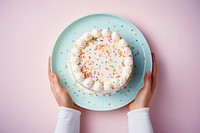 Hands holding birthday cake on plate sprinkles dessert food. AI generated Image by rawpixel.
