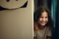 Smiling girl hiding behind gift box portrait smile child. AI generated Image by rawpixel.