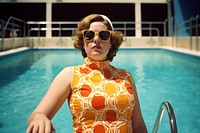 A confident over-weight woman wearing two-piece swimming suit photography sunglasses portrait. 