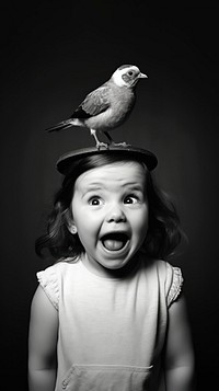 A little girl making funny face because a cute bird stand on her head photography portrait animal. 