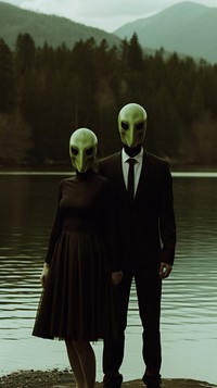 A couple wearing alien mask dressing beautiful standing infront of the river photography portrait outdoors. 
