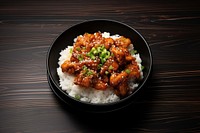 A korean fries chicken on top of the rice in the black bowl on the black wood table food meat chopsticks. AI generated Image by rawpixel.