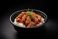 A korean fries chicken on top of the rice in the black bowl on the black wood table food vegetable condiment. AI generated Image by rawpixel.