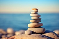 A Six rocks are stacked on top of each other pebble blue sky. AI generated Image by rawpixel.