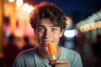 Young man eating orange ice lolly adult food face. 