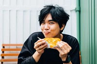 Young handsome Hong Kong man enjoying local street food adult freshness happiness. AI generated Image by rawpixel.