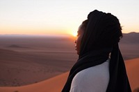 Black young woman watching sunset at desert outdoors horizon nature. 