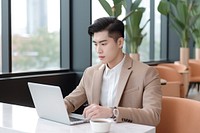 Chinese Businessman typing and replying email by a laptop furniture computer chair. AI generated Image by rawpixel.