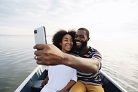 Happy black young couple taking selfie in boat travel happy photographing. AI generated Image by rawpixel.