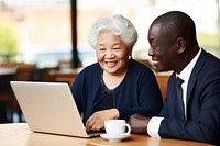 Happy senior old korean businesswoman discussing online project on laptop with african american male computer adult happy. AI generated Image by rawpixel.
