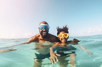 Smiling black family on snorkeling tour in tropical ocean recreation swimming outdoors. 