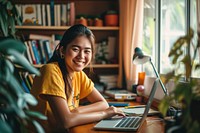 A smiling girl doing work at home laptop computer sitting. AI generated Image by rawpixel.
