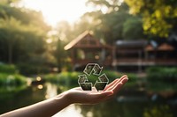 Hand holding a recycle icon outdoors nature reflection. AI generated Image by rawpixel.