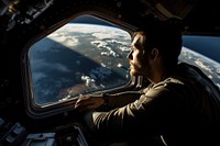 An astronaut looking out of the spacecraft window airplane vehicle adult. 