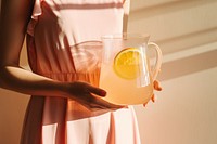Female holding clear pitcher of water lemonade yellow drink. AI generated Image by rawpixel.