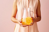 Female holding clear pitcher of water glass yellow juice. AI generated Image by rawpixel.