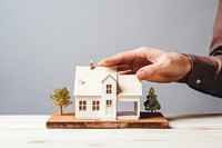 Male hand holding a model house wood toy architecture. AI generated Image by rawpixel.