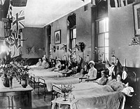 Hahnemann Hospital and Homœopathic Dispensaries, Liverpool: a women's ward, decorated with flags possibly for the coronation of King George V. Photograph.