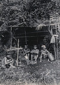Sarawak: four Kayan hunters in their camp. Photograph.