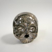 Skull, heavy, hammered and soldered silver work. A solder line bisects the skull vertically, parallel to the face. The incised lines representing sutures are independent of the solder line. Insets in the eye-sockets were once filled with inlaid stones or shells.. Original from the Minneapolis Institute of Art.
