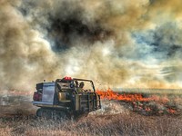 2021 USFWS Fire Employee Photo Contest Category: EquipmentA USWS firefighter monitors a prescribed fire at Morris Wetland Management District in 2020. Photo by Phil Millette, FWS