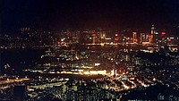 Historical Hong Kong: Lunar New Year '96Hong Kong Island and the Kowloon peninsula, as seen from somewhere near Lion Rock, sometime around Lunar New Year, 1996. The afternoon of my hike on the day I took this shot was balmy for winter, and I was wearing only shorts and a t-shirt. Originally, I had intended to descend from the trail before dark, but discovering my daypack still had a torch in it from a previous dusk hike, I decided to hang around a couple of hours for a few night shots (without a tripod, and long before image stablisation). All I can remember is, I was so cold by the time it was truly dark I could hardly stop myself shaking like a leaf, let alone keep the camera still! By the time I took this shot, it was pitch black, and the torch battery was nearly flat, so most of the hike back down was in near complete darkness! The things we do for pictures...