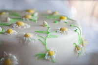We are close up on the details of this adorable cake, covered in white fondant and decorated with fondant daisies and delicate green fondant vines.
