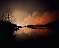 Winner - Landscape Category - USFWS 2022 Photo/Video ContestA 2022 prescribed fire at Sequoyah National Wildlife Refuge in Oklahoma glows on the water at night. Photo by Damon Taylor/USFWS