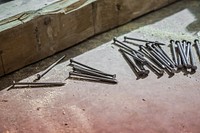 Nails and sawdust rest beside a wood beam on a construction site, free public domain CC0 image.