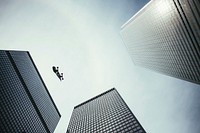 A skateboard falls in the sky between tall city skyscrapers, free public domain CC0 photo.